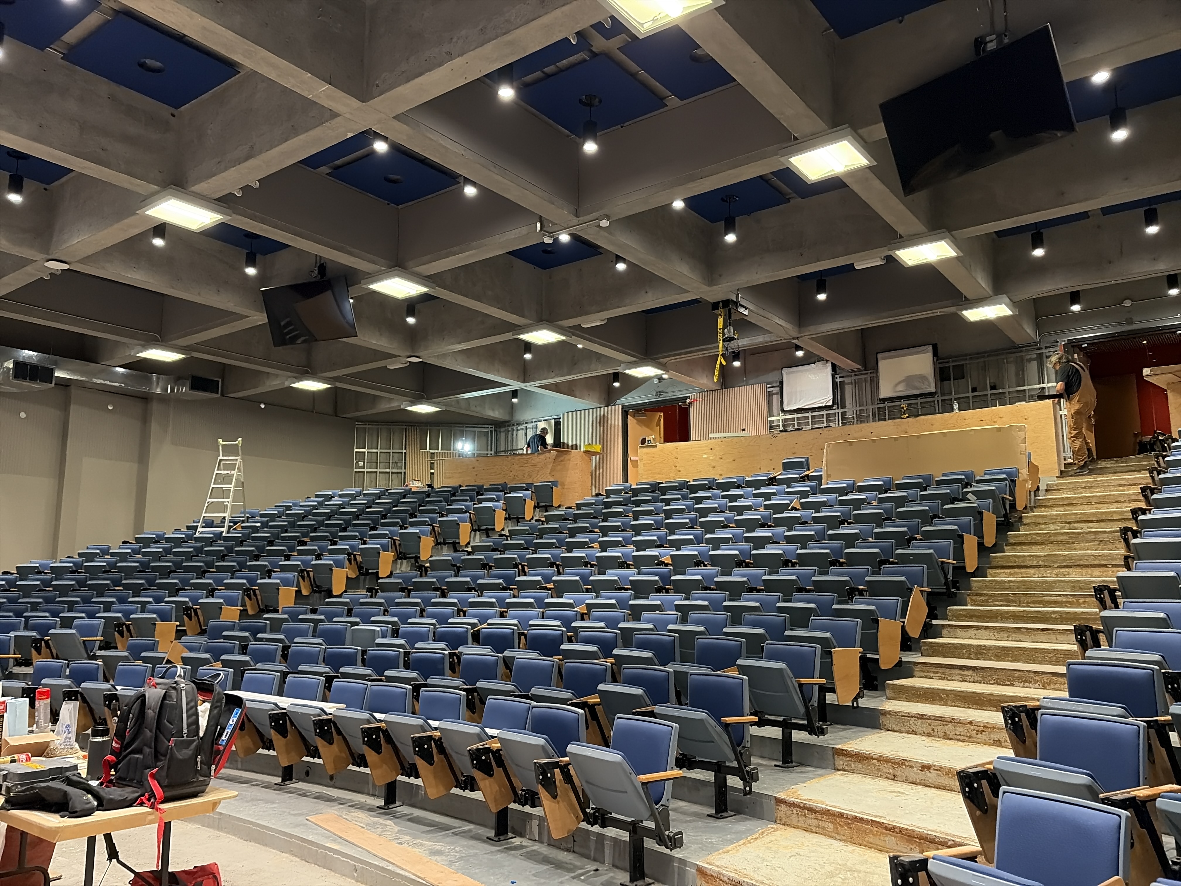 Tiered seating and blue inset ceiling panels at SFU Images Theatre during construction